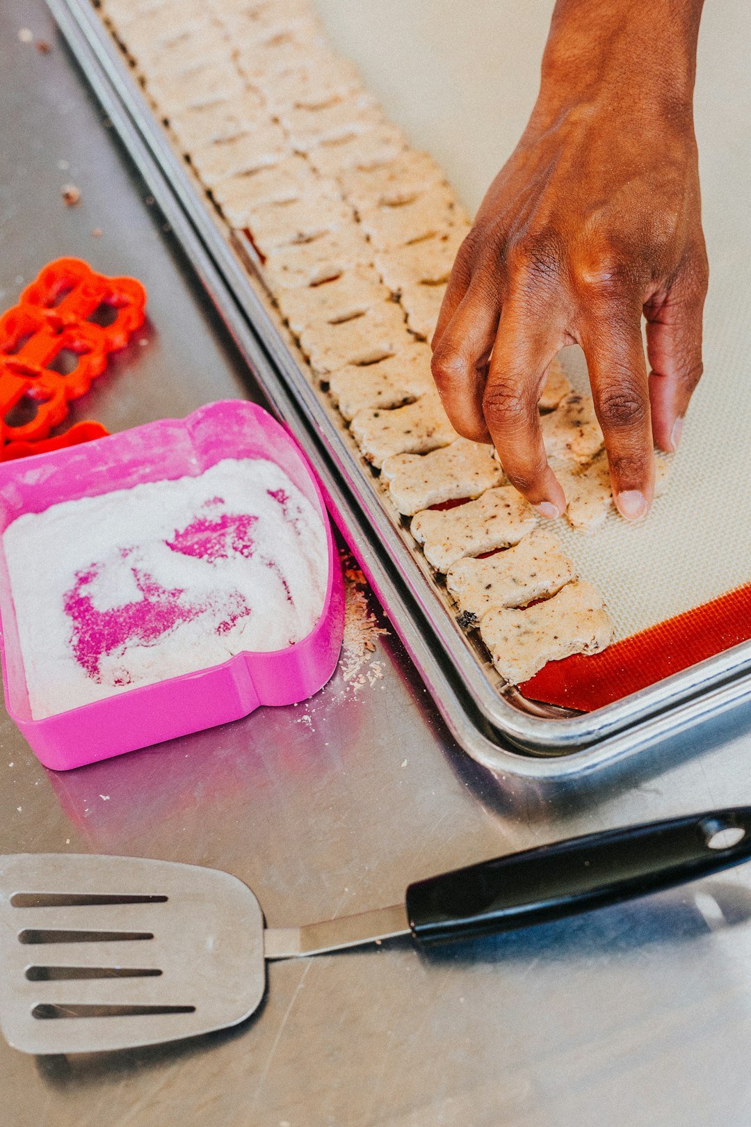 Arins is an inclusive workplace for disabled individuals that makes dog treats, pictured you will see one of our workers cutting out dog biscuits for going into the oven